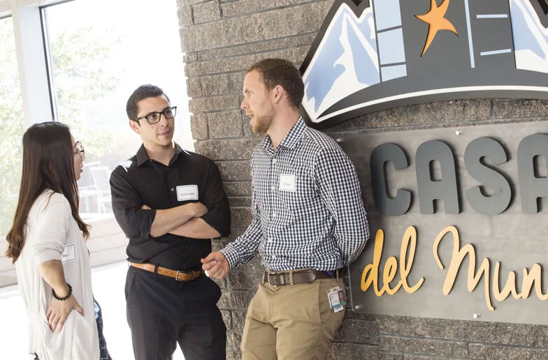 A line of summer analyst interns standing in a conference room.